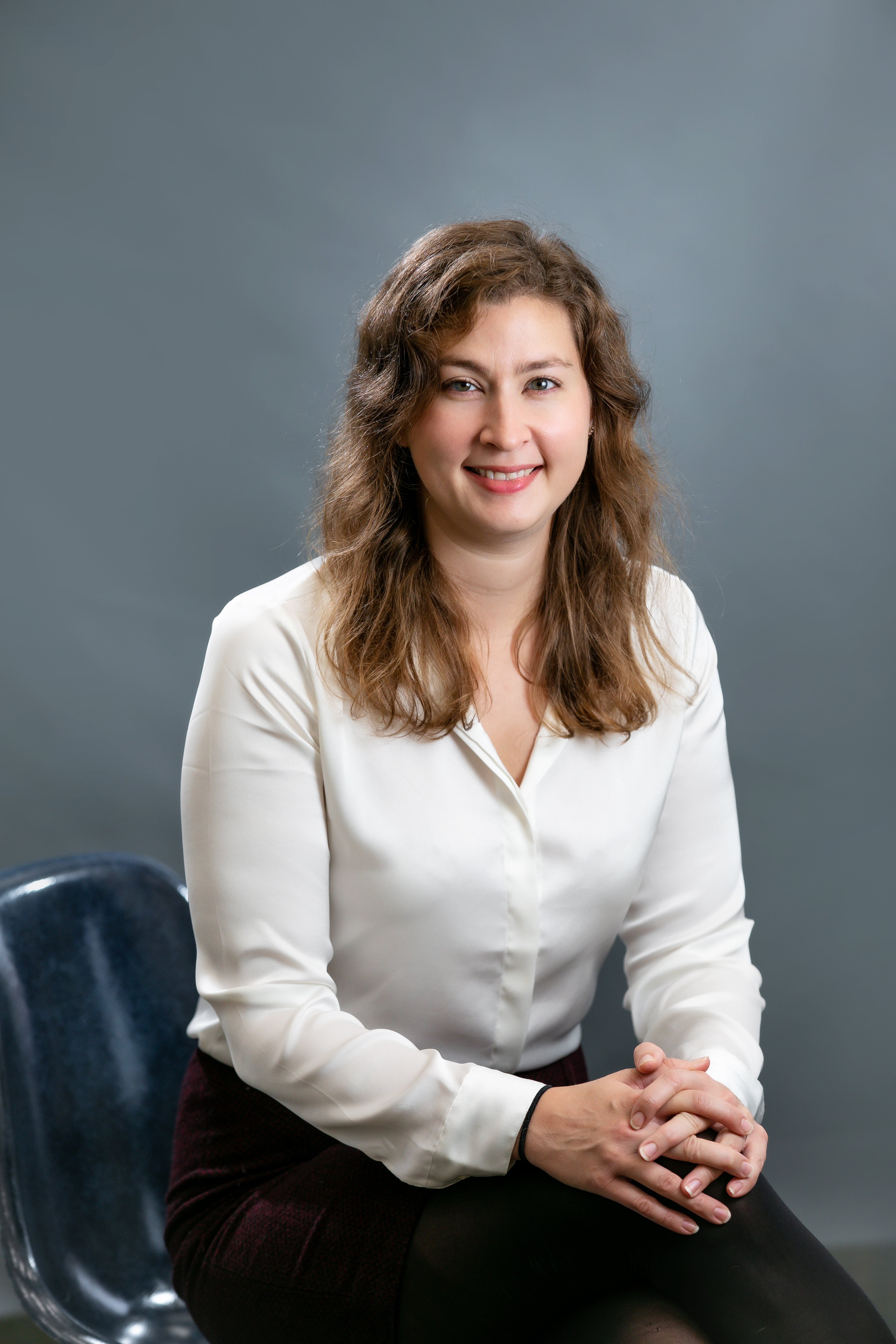 Sarah Fitzgerald, a white woman with light-brown hair who is wearing a white blouse.