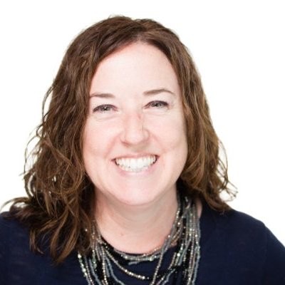 Kathleen Carr, a white woman with brown hair wearing a black shirt and silver necklaces.