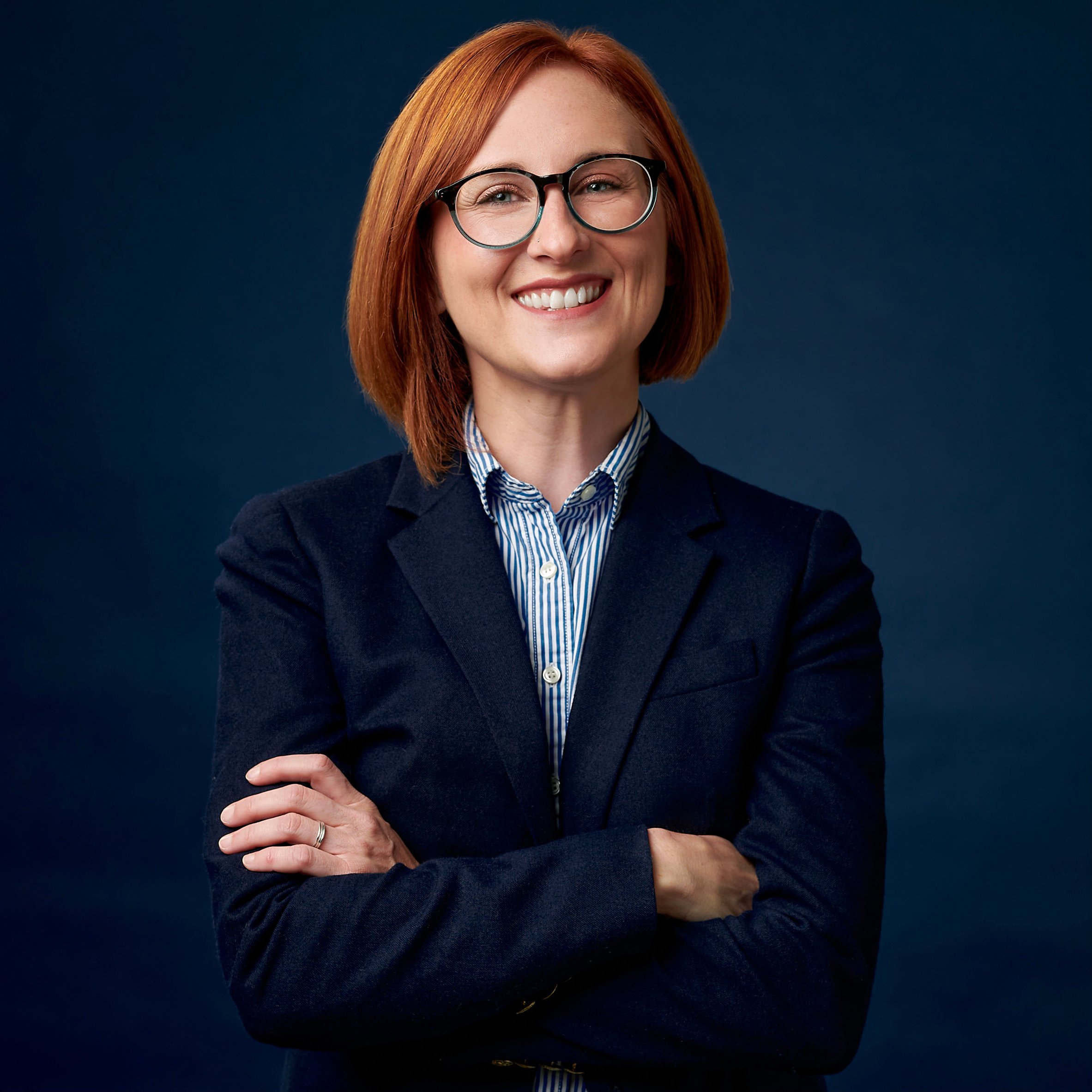 Brit Blalock, a white woman with red hair and glasses.