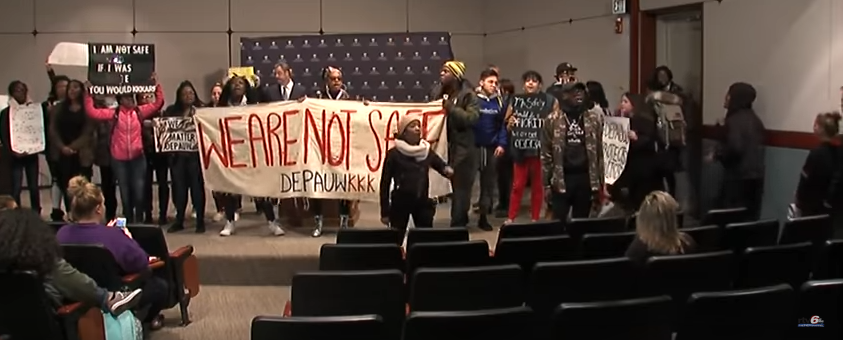 Protesting DePauw students hold signs saying "I am not safe" and "We are not safe DePauw KKK."