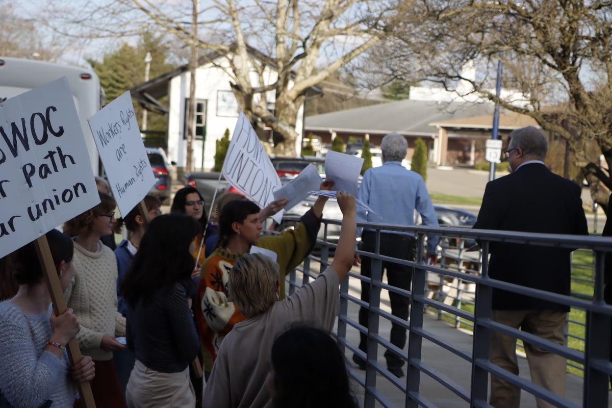 Striking students hold signs; one says, "Workers' rights are human rights."