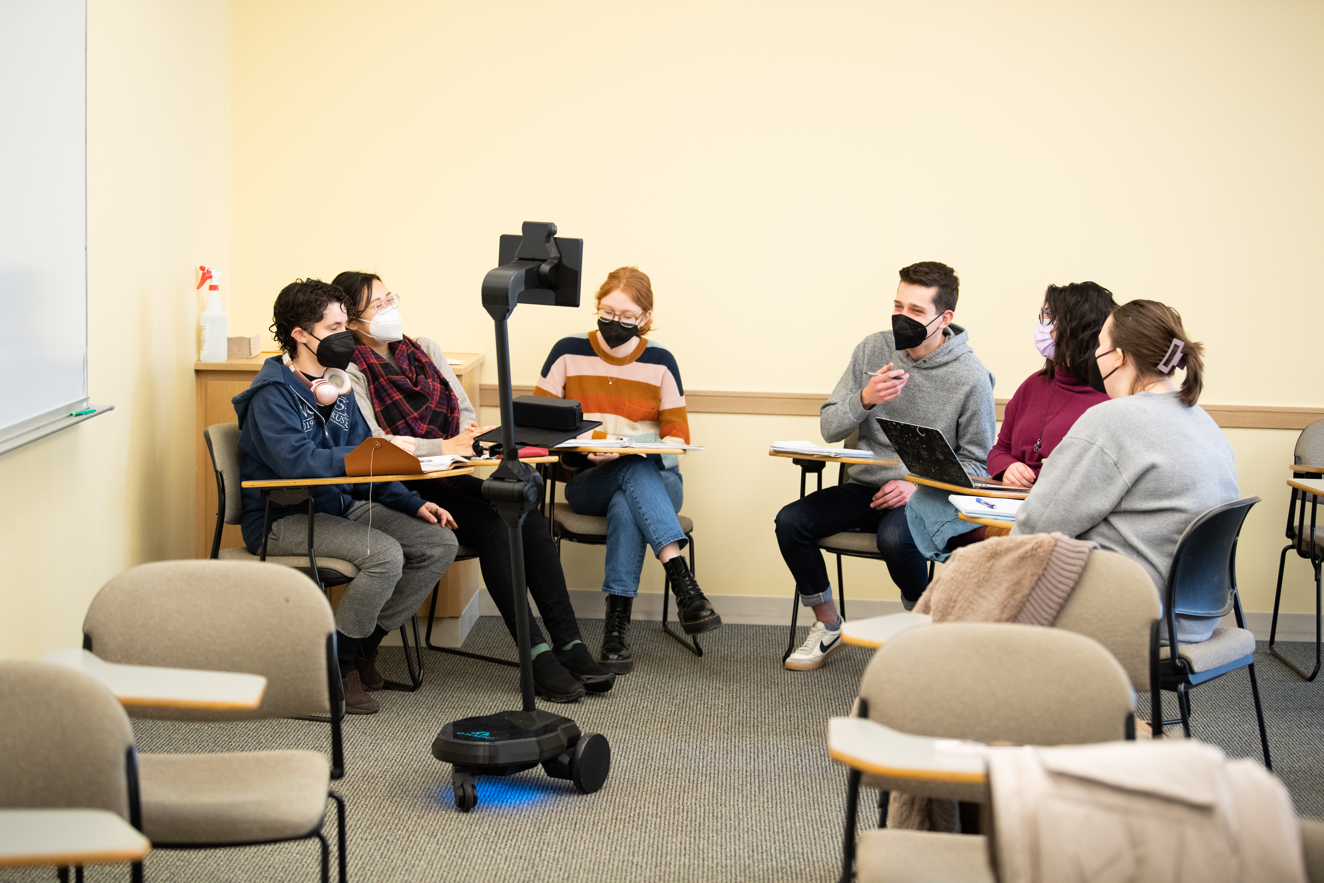 Students sitting in a circle with robots.