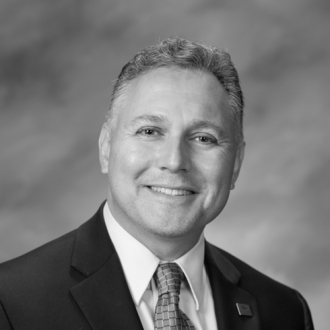 A black-and-white photo of Dan Silber, a middle-aged man with curly hair.