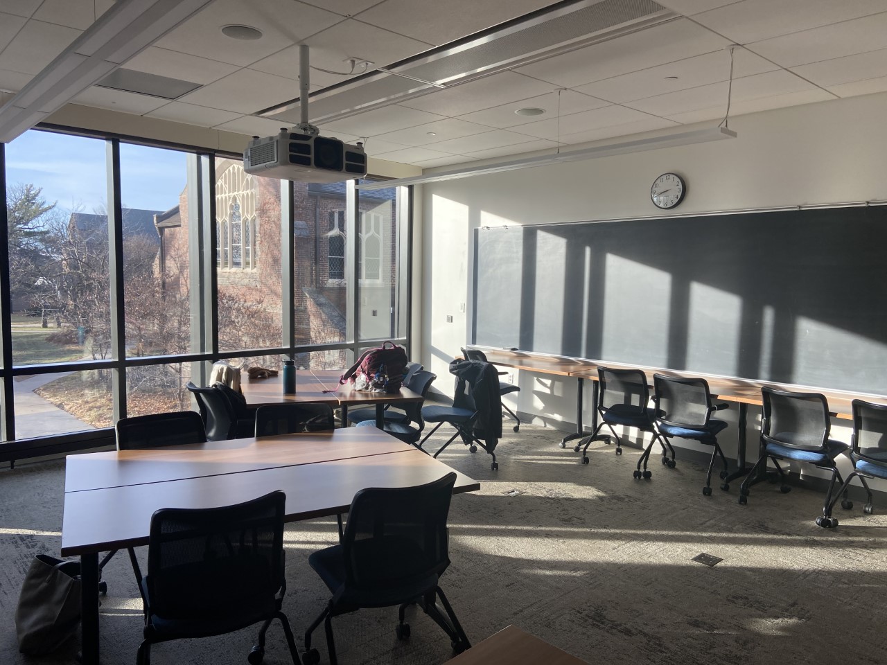 A classroom with tables, chairs, and a blackboard in the humanities center.