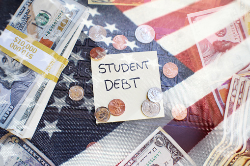 Composite photo of an American flag, a stack of hundred-dollar bills, coins, and the words "Student debt."