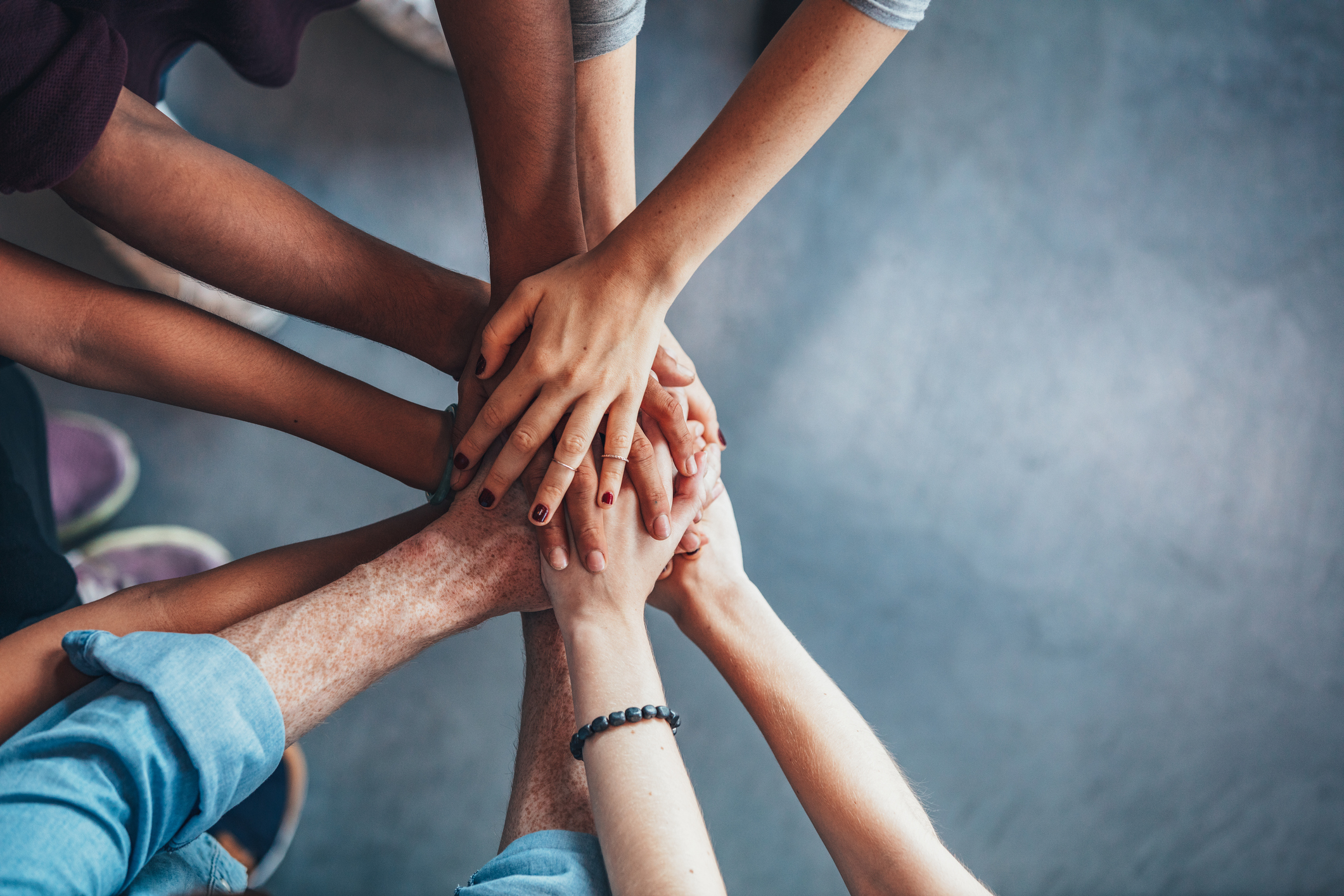 Image of a number of people joining hands.