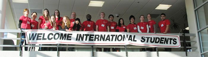 College students with a banner saying "Welcome International Students."