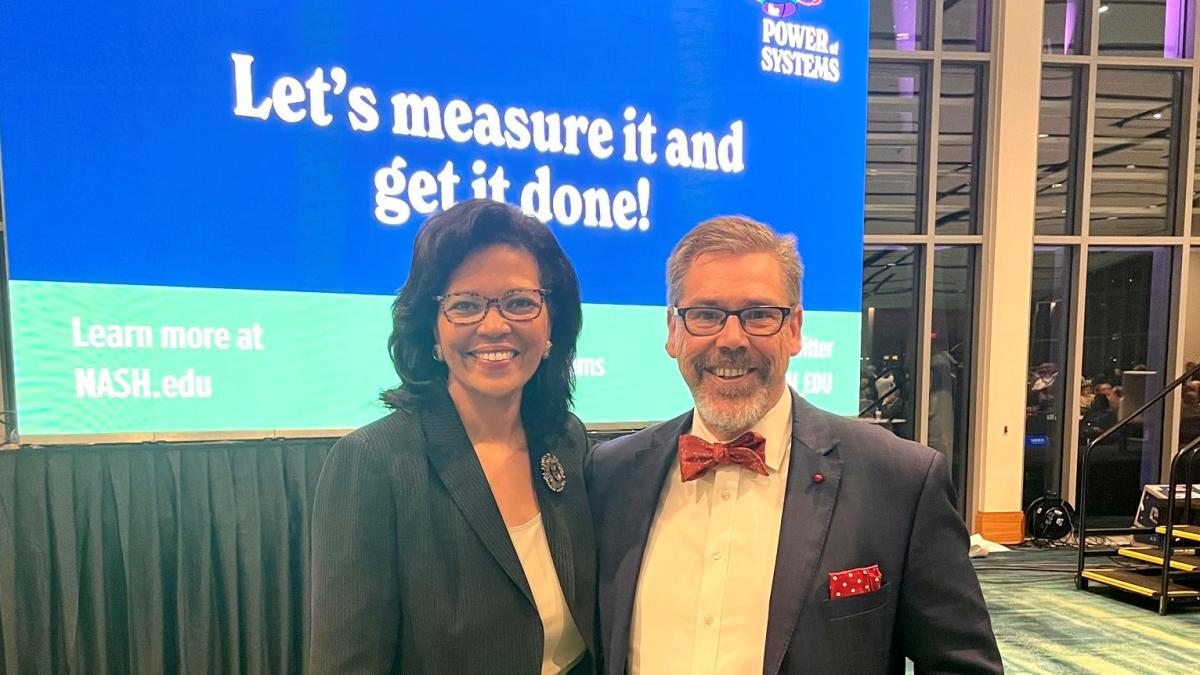 Kim Hunter Reed, a Black woman with dark hair wearing glasses, and Tristan Denley, a white man wearing glasses and a bow tie.
