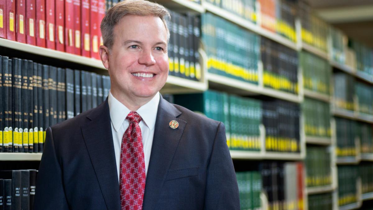 Rick Bailey, a white man with sandy hair wearing a business suit, in a library.