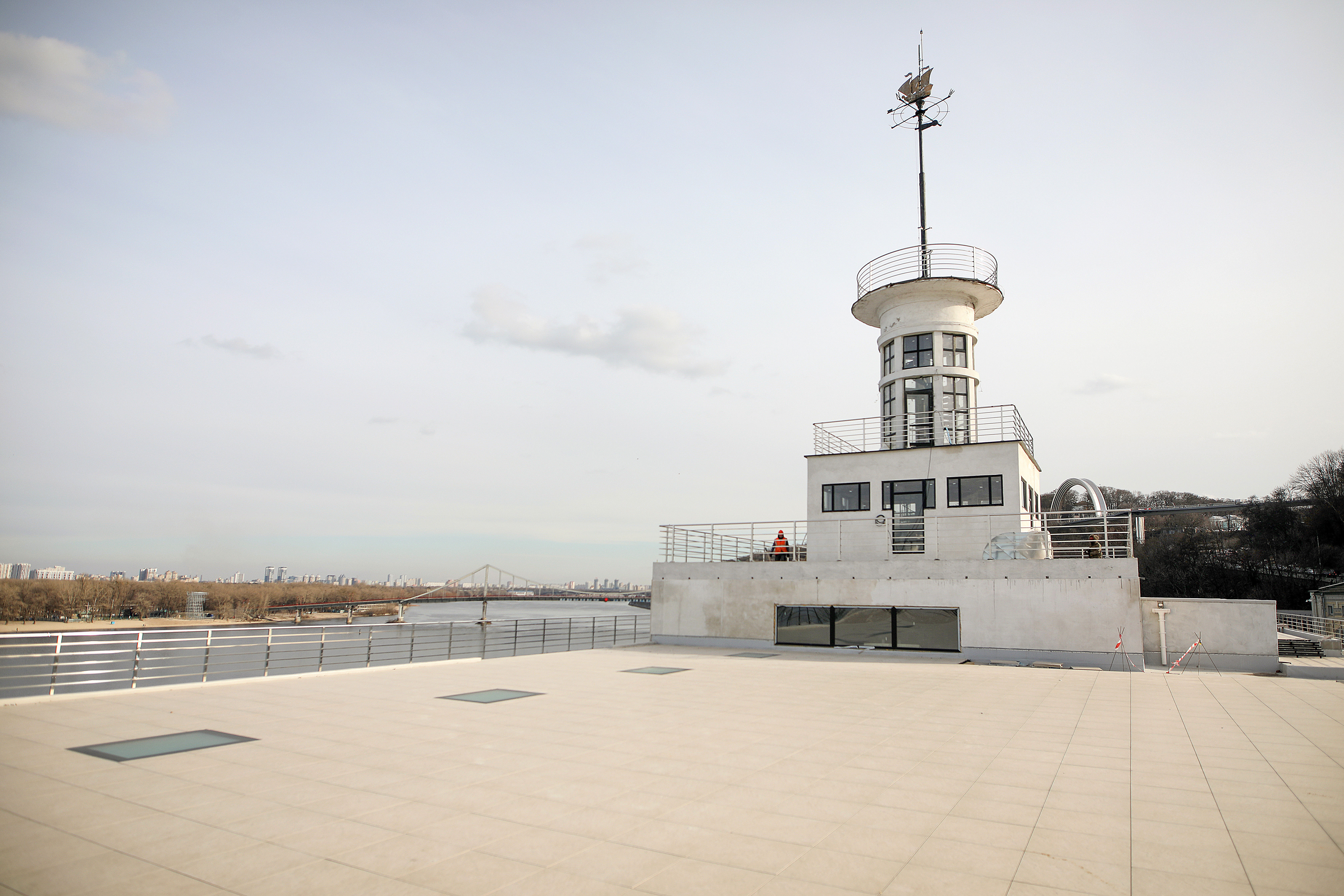 A rooftop with an observation tower overlooking a river