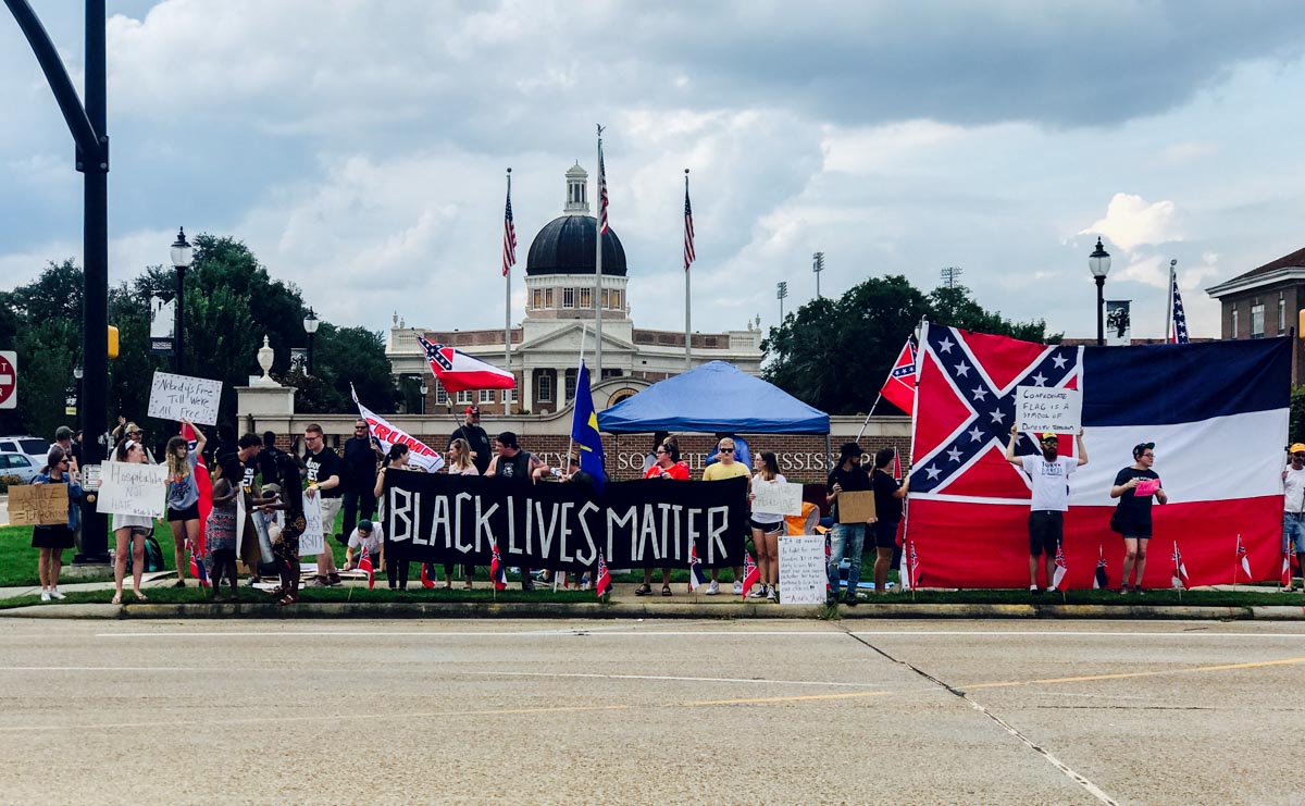 Image of Aug. 13 protest shows a sign with the words "Black Lives Matter," as well as Confederate and Mississippi flags.