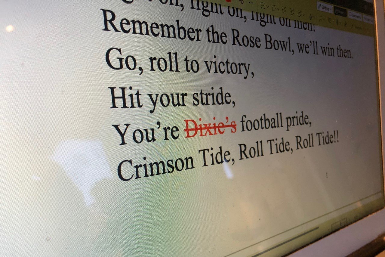 A computer depicting the following lyrics from “Yea Alabama!”: “Remember the Rose Bowl, we’ll win then. Go, roll to victory, hit your stride, you’re Dixie’s football price, Crimson Tide, Roll Tide, Roll Tide.” The word “Dixie” is red and crossed out.