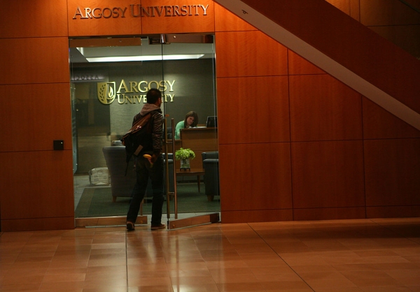 Student walking through glass doors of Argosy School