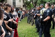 A line of Texas State Troopers and other members of law enforcement face a line of pro-Palestine student protesters